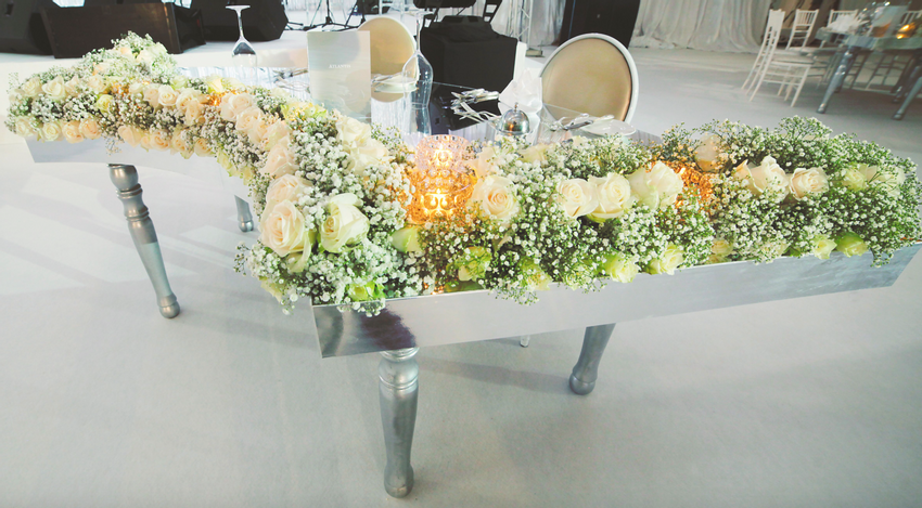 Lush floral displays surrounding the couple's sweetheart table