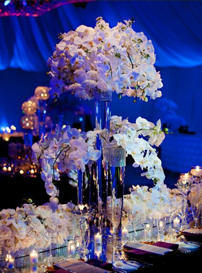 Stunning table décor with white roses and tall centerpieces full of white orchids 