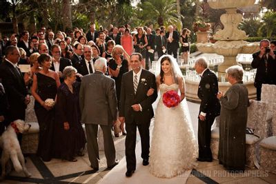 The excited bride in her Monique Lhuillier wedding gown walking towards her groom with her father
