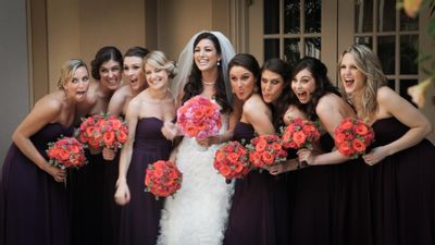 The bride in her Monique Lhuillier surrounded by her bridesmaids in their Bari Jay dresses with their rose and baby's breath wedding bouquet