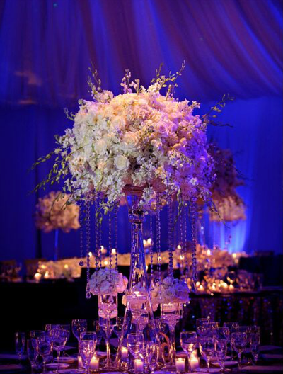 Tall crystal centerpieces full of white roses with cascading crystals 