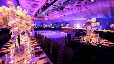 Canopied ballroom decorated with orchids and elegant dance floor