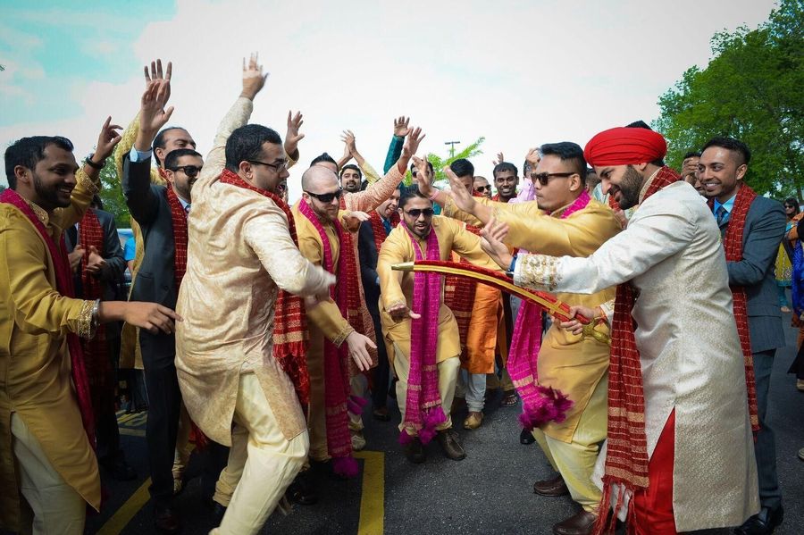 The groom in traditional Sikh Attire while dancing with his traditional sword 