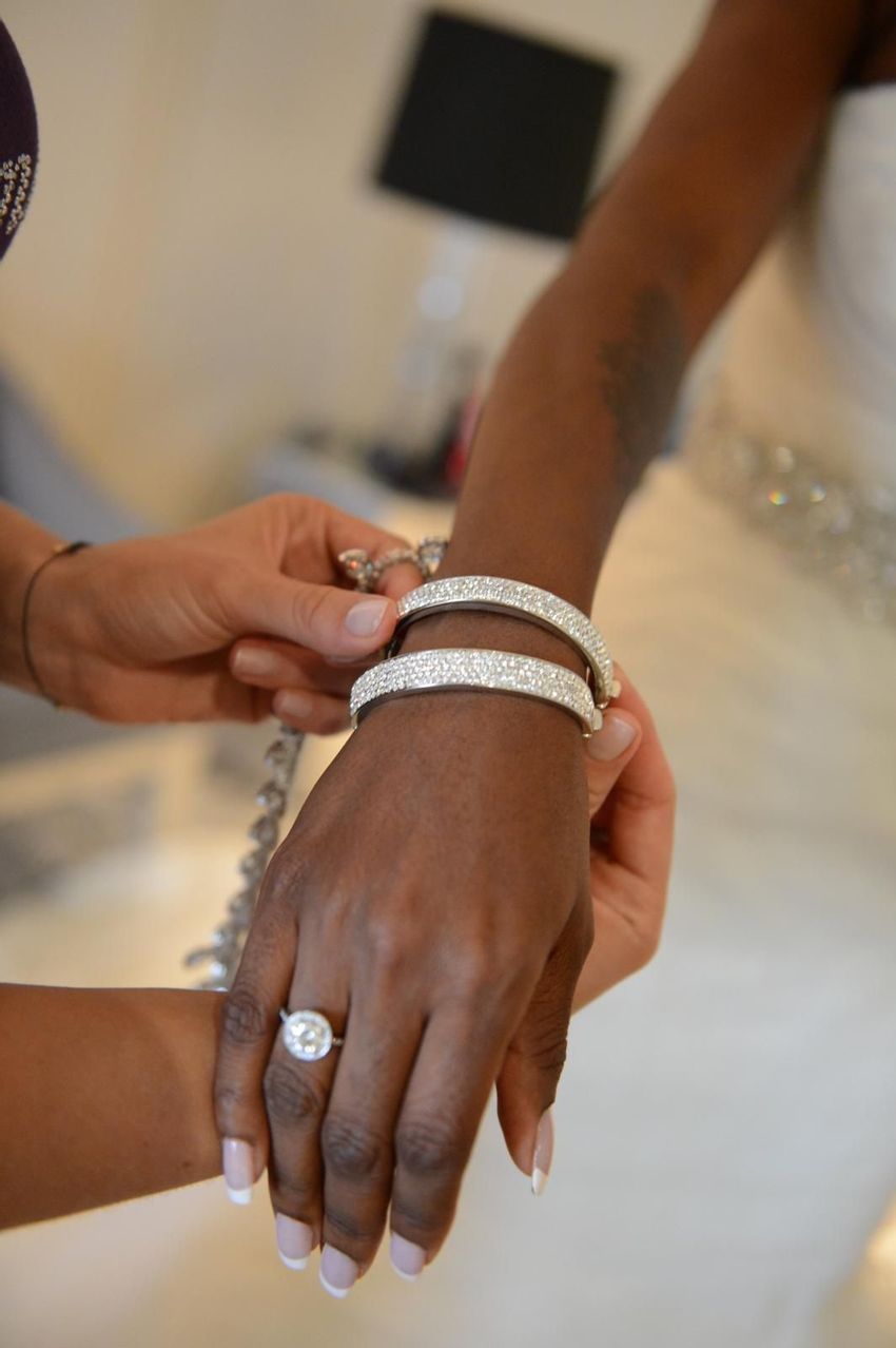 Bride getting helped to wear her wedding day bracelet