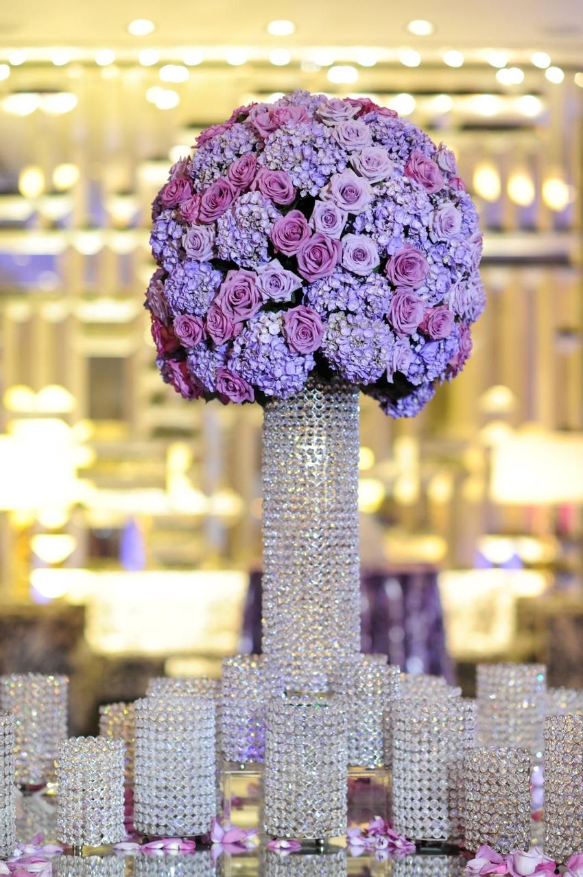 Multi level vases adorned with crystals and purple hue floral arrangement with roses and hydrangea 
