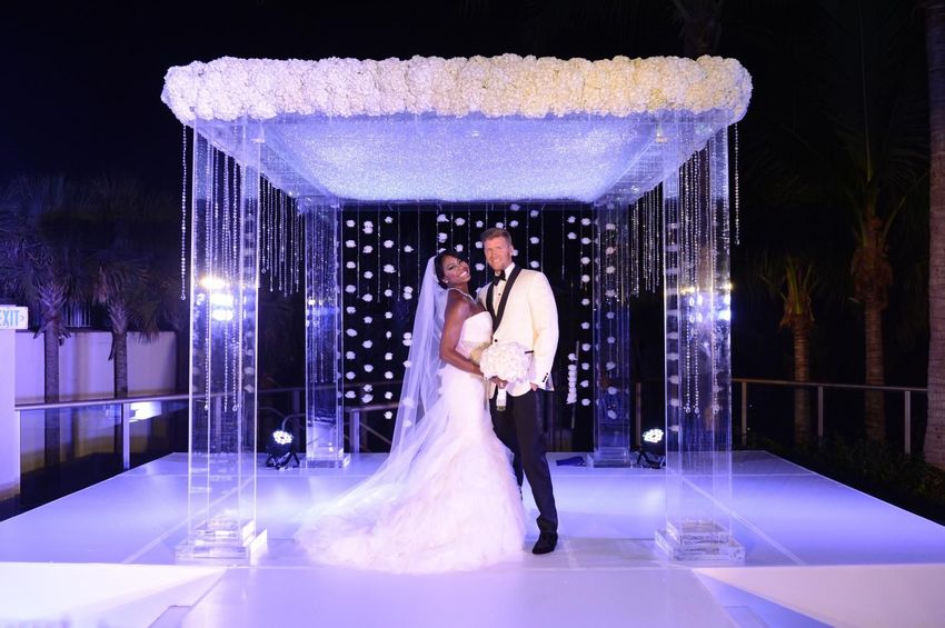 Newly married couple under mirrored wedding arch at The St. Regis Resort, Bal Harbour